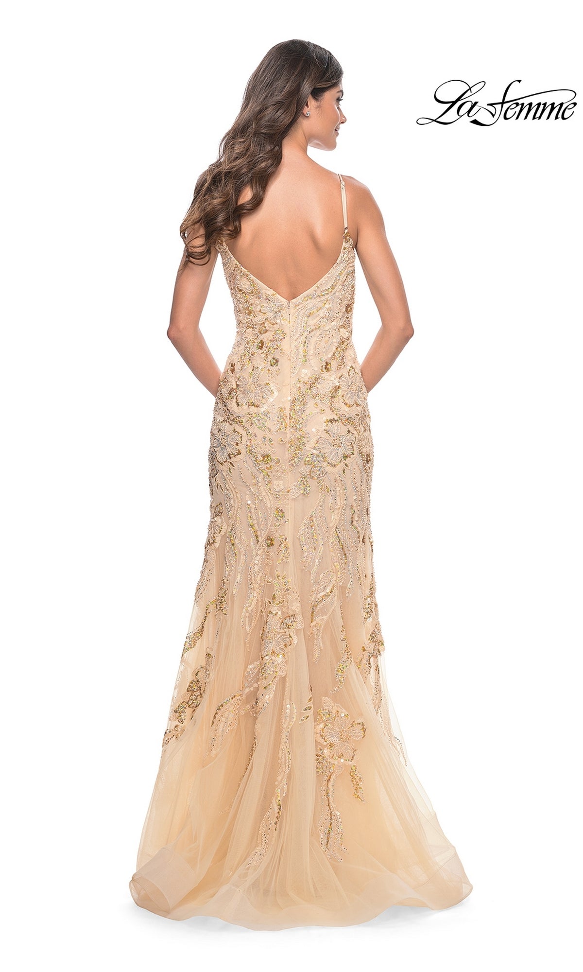 A woman faces away, wearing the Le Femme Long Sequin-Lace Prom Dress 32333. This fitted gold mermaid gown features spaghetti straps, a low back, intricate embroidery, and a floor-length flared skirt for an elegant look.